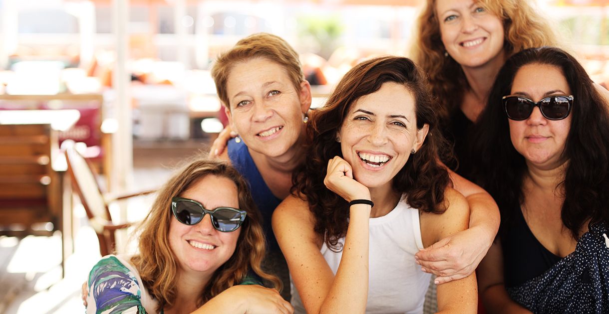 Μια ομάδα 5 γυναικών που γελάνε αγκαλιασμένες